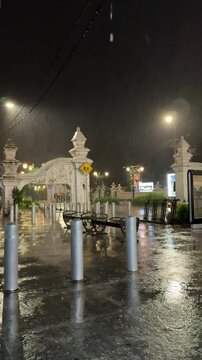 Night Rainfall at the Gate of Yogyakarta Palace Area &ndash; Wet Street Reflections, Benches, and Traditional Javanese Architecture in Tropical Storm Atmosphere, Indonesia