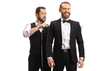 Tailor taking measures for a mans suit