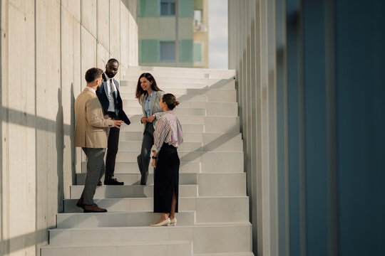 Business people talking on stairs of modern office building