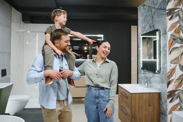 Fototapeta premium Happy family choosing bathroom fixtures in plumbing store
