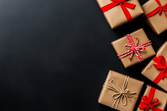 An array of beautifully wrapped gifts with elegant red ribbons and twine bows, set against a dark background. This image conveys a sense of anticipation and celebration.