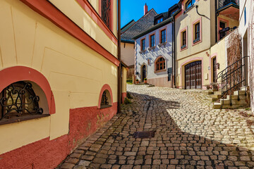 Charming cobblestone street with colorful european architecture in sunlit village