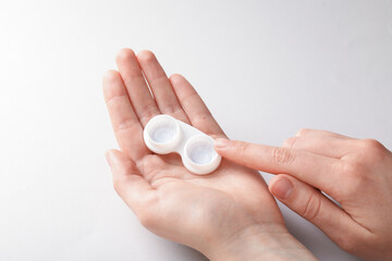 Woman with contact lenses on light background, closeup