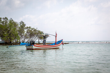 Small fishing boat in Ko Samui, Image shows a small boat anchored in the shallow turquoise waters 