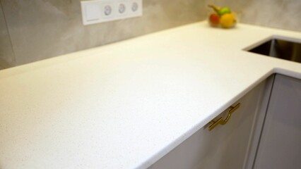 White quartz kitchen countertop with gold handles showing modern design