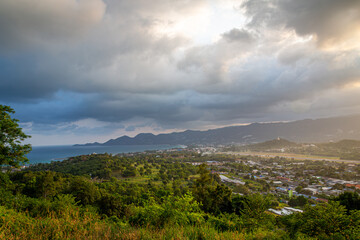 Ko Samui at sunset, Image shows sunset over the small island from the top of a mountain overlooking the airport, runway  and nearby town 