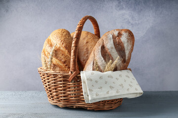 Many bread loaves and spikes in basket on grey wooden table