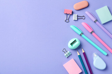 Pens and other stationery on violet background, flat lay. Space for text