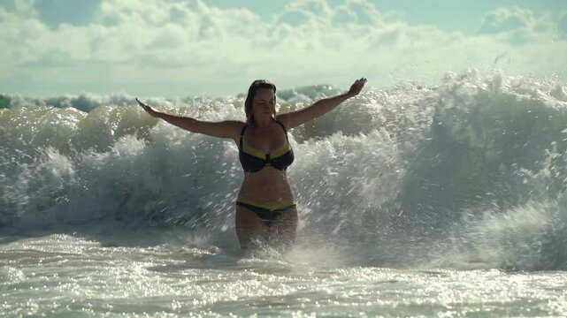 Sea waves hit a girl in the open sea in slow motion
