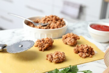 Making ravioli bolognese at white marble table, closeup