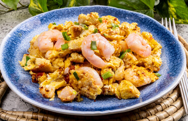 Shrimp omelet on a plate with large cooked shrimp on top