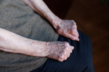 Elderly woman sitting with clenched fists