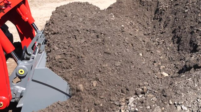 Industrial compact track loaders grading, leveling and clearing construction job sites, powerful machinery working on gravel and leveling the ground stage of building road