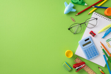 Educational supplies including stationery and a notebook on a green background for studying and creativity