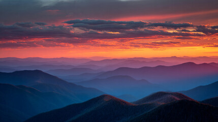 Obraz premium A scenic view of layered mountain ranges under a vibrant sunset with colorful clouds above the peaks