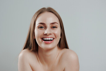 Smiling woman with long hair poses against a light background in a joyful moment during a casual...