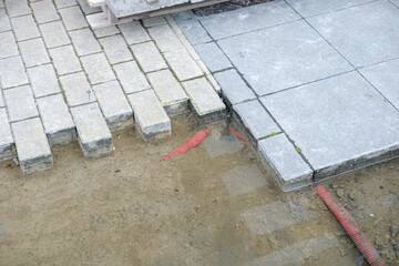 Fototapeta premium construction background. stacked paving blocks and work buckets, paver installation in progress with flexible work tubs