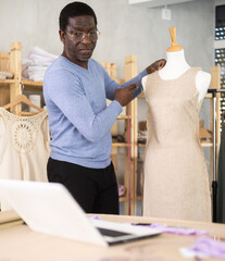Professional fashion designer participating in remote consultation via video call using laptop in...