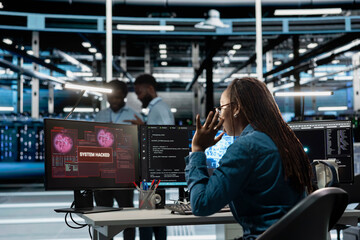 Engineer in AI server hub panicked by hacker attack stealing sensitive information, trying to protect hardware. Artificial intelligence data center worker scared by virus during security breach © DC Studio