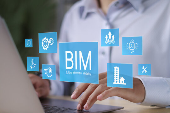 BIM (building information modeling) technology concept. Businessman using computer laptop with l BIM icons on virtual screen.