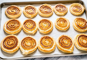 A tray of freshly baked cinnamon rolls on a table.