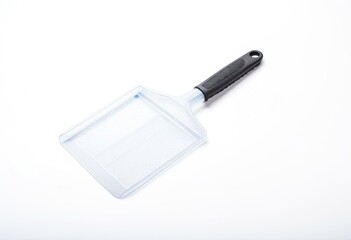 A green spatula on a white surface.