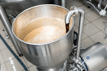 Stainless steel brewing equipment in active beer factory setting