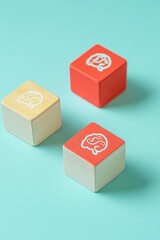 Fototapeta premium Three wooden blocks, two light orange, one red, each displaying a brain icon