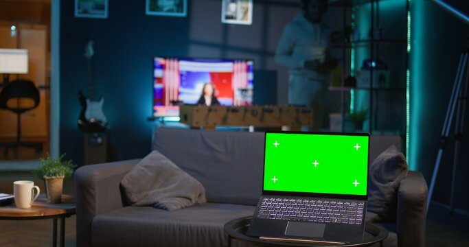 Fototapeta African american person enjoying music on headset next to copy space screen, feeling happy with remote work and relaxing on the sofa. Relaxed chill guy sitting in his trendy apartment. Camera B.