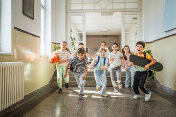 boys and girls classmates run through the school hallway