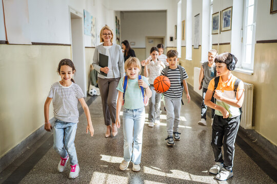boys and girls classmates walk to classroom through the school hallway