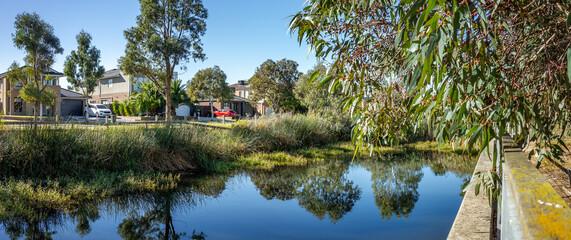 Panoramic view of urban wetland in a residential suburban neighborhood of Australia, with water...