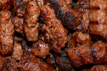 Delicious romanian mici, traditional grilled minced meat rolls, filling the frame