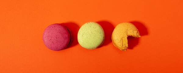 Macaroons on orange background. Flat lay.
