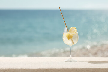 refreshing lemonade cocktail placed on serene surface by beach with gentle waves in background