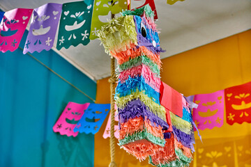 Classic Mexican llama pinata hanging in vibrant colors, surrounded by festive papel picado decorations, creating a joyful atmosphere for celebrations and parties