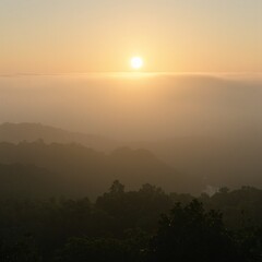 Obraz premium Tranquil sunrise over misty hills bathed in warm oranges and soft greens Perfect for serene nature or calming landscape concepts