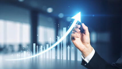 Realistic image of a hand drawing an upward arrow on a transparent screen, with bright light effects, financial charts overlay, and symbols of profit and business growth.