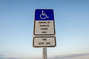 Handicap Blue and White Sign Reading Parking By Disabled Permit Only, Fine $250 Max at the Beach