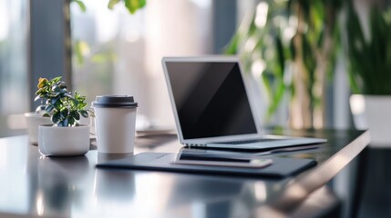 Modern workspace setup featuring laptop, coffee cup, and indoor plant arrangement