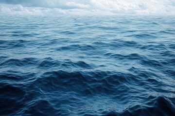 Fototapeta premium Calm ocean with gentle waves under a cloudy sky, capturing the vastness and tranquility of open water
