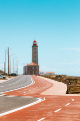 Lighthouse (Farol do Penedo da Saudade) standing tall along scenic coastal road in Marinha Grande, Portugal