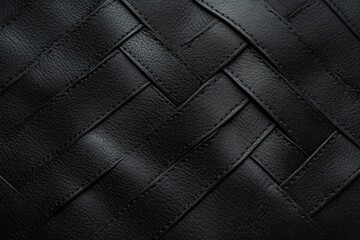 Fototapeta premium Close-up of black leather strips woven together creating a textured, patterned surface with visible stitching and a soft sheen