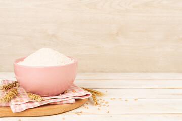 Bowl with spelt flour on wooden table
