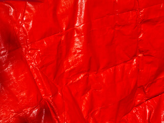 Red background. Red tarpaulin PVC background. Red aesthetic. Red plane surface. Wrinkle texture. Reusable material. Tarp backdrop. Polymer. Polyvinyl chloride. Durable material. PVC canvas. Red layout