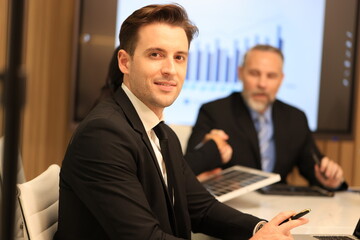 Diverse Team Working Together in Modern Co-Working Space. Casual meeting of smiling diverse business team analyzing financial data. Multiethnic business people working together in the office.