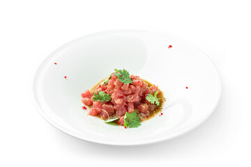 Tartar with tuna, avocado and sauce decorated with cilantro on plate isolated on white background....