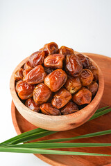 Dates fruit sukari or kurma sukari, in wooden bowl isolated on white background