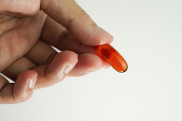 Male hand holding Oil filled capsules, softgel of food supplements, fish oil, omega 3, vitamin E