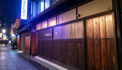 Obraz premium Night View of Traditional Japanese Wooden Building in City Street